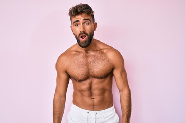 Fototapeta premium Young hispanic man standing shirtless afraid and shocked with surprise expression, fear and excited face.