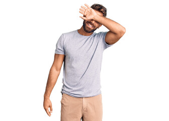 Young hispanic man wearing casual clothes covering eyes with arm smiling cheerful and funny. blind concept.