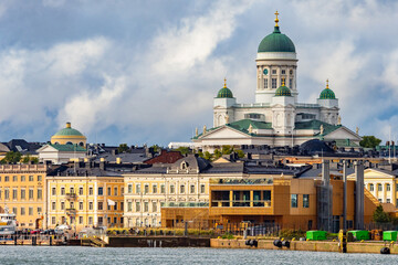 Panorama of the port of Helsinki. View of the capital of Finland. Buildings on the Helsinki waterfront. Suurkirkko on the background of low buildings. The Cathedral of St Nicholas in Helsinki.