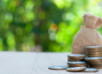 stack of coins with pills on the table in the nature blurred background