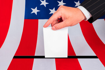 Voting in the US Presidential election. A man puts a ballot in the ballot box. An American votes at a polling station. A man casts his vote for the American presidential candidate. USA election 2020.