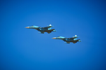 Two russian Su-34 Fullback fighter-bombers flying on the clean sky background
