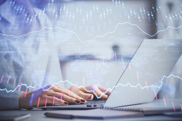 Double exposure of woman hands working on computer and forex graph hologram drawing. Financial analysis concept.