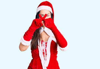 Young beautiful caucasian woman wearing santa claus costume rejection expression crossing fingers doing negative sign
