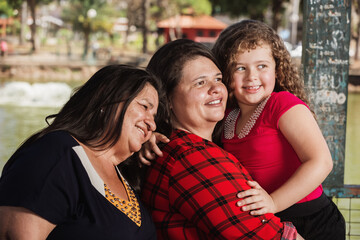 three generations with grandparents daughter and granddaughter outdoors happy