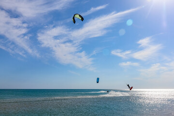 a kitesurfer surfing on the smooth azure water. recreational sport. A Man Rides A Kiteboarding In The Sea Water. extreme sport. Jump