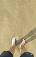 Barefoot in clear water on the beach