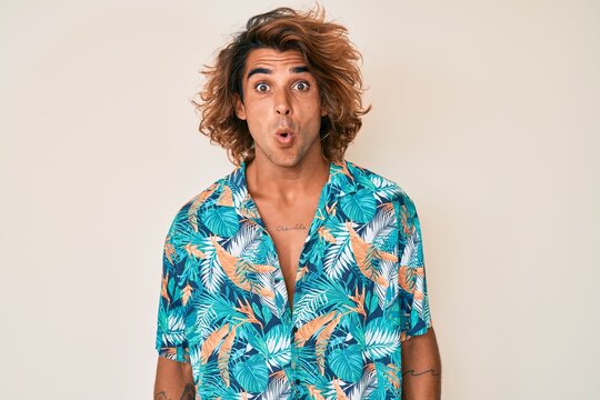 Young hispanic man wearing summer shirt scared and amazed with open mouth for surprise, disbelief face