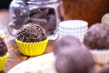 Brigadeiro ou negrinho, typical candy for children's birthday parties in brazil, punctual focus, on rustic table