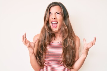 Beautiful young caucasian woman wearing casual clothes crazy and mad shouting and yelling with aggressive expression and arms raised. frustration concept.