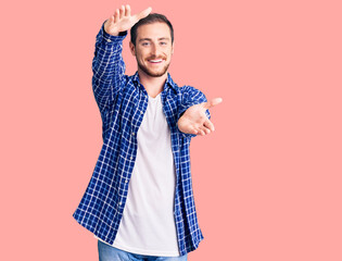 Young handsome caucasian man wearing casual clothes looking at the camera smiling with open arms for hug. cheerful expression embracing happiness.