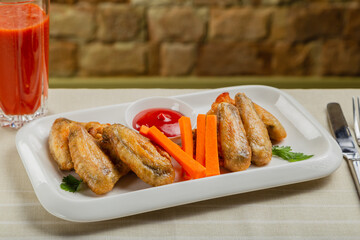 Fresh fried chicken wings on a white plate.