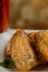 Fresh fried chicken wings on a white plate.