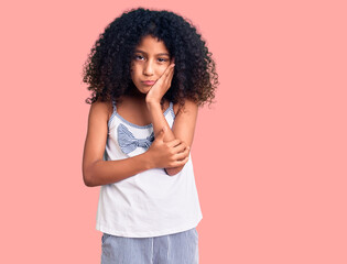 Fototapeta na wymiar African american child with curly hair wearing casual clothes thinking looking tired and bored with depression problems with crossed arms.