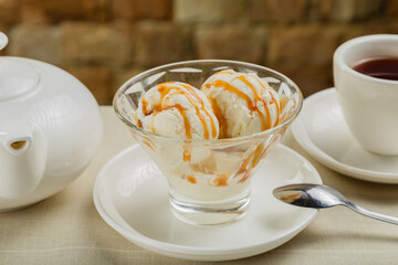 White ice cream in a glass glass with caramel.