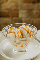 White ice cream in a glass glass with caramel.
