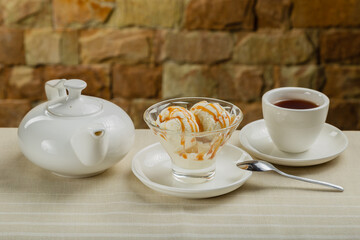 White ice cream in a glass glass with caramel.