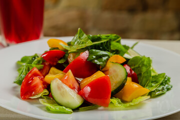 Summer fresh salad of tomato cucumber leaves lettuce.