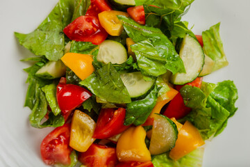 Summer fresh salad of tomato cucumber leaves lettuce.