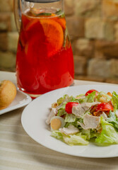 Fresh caesar salad in a white plate on the table.