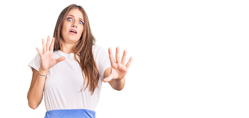 Young beautiful blonde woman wearing summer style afraid and terrified with fear expression stop gesture with hands, shouting in shock. panic concept.