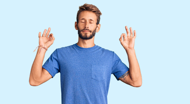 Handsome blond man with beard wearing casual clothes relax and smiling with eyes closed doing meditation gesture with fingers. yoga concept.