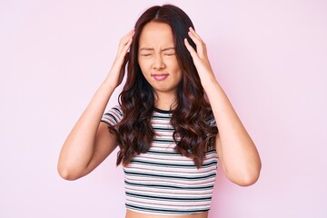 Young beautiful chinese girl wearing casual clothes suffering from headache desperate and stressed because pain and migraine. hands on head.