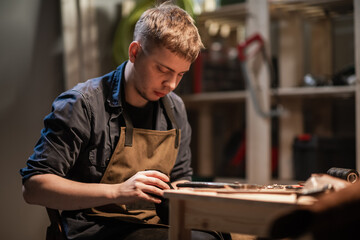 a young apprentice makes blanks for the production of shoes in the workshop