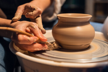 beautiful hands of a young girl Potter in the process of sculpting a vase with clay and tools