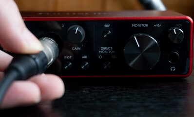 person connecting a cable to an audio interface