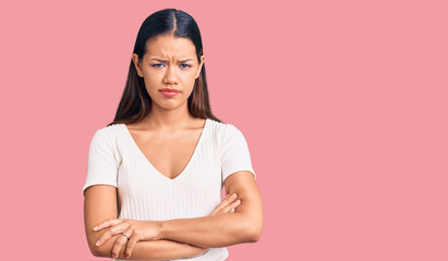 Young beautiful latin girl wearing casual white t shirt skeptic and nervous, disapproving expression on face with crossed arms. negative person.