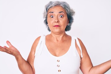 Senior hispanic woman wearing casual clothes clueless and confused expression with arms and hands...