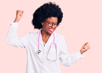 Young african american woman wearing doctor coat and stethoscope dancing happy and cheerful,...
