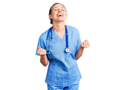 Young beautiful blonde woman wearing doctor uniform and stethoscope very happy and excited doing winner gesture with arms raised, smiling and screaming for success. celebration concept.