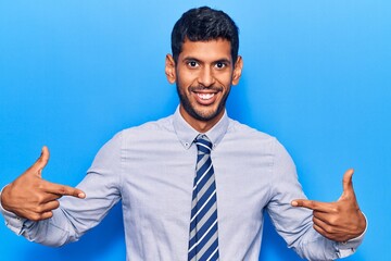 Young latin man wearing business clothes looking confident with smile on face, pointing oneself...