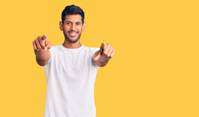 Young latin man wearing casual clothes pointing to you and the camera with fingers, smiling positive and cheerful