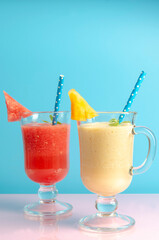 Watermelon and melon smoothies in a glass on colored