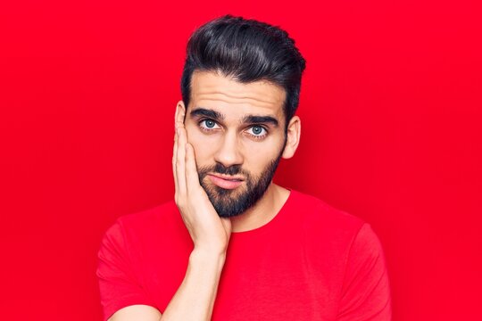 Young handsome man with beard wearing casual t-shirt thinking looking tired and bored with depression problems with crossed arms.