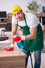 Young male contractor cleaning the office