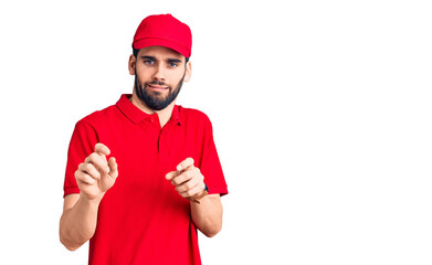 Young handsome man with beard wearing delivery uniform disgusted expression, displeased and fearful doing disgust face because aversion reaction.