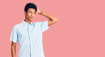 Young african american man wearing casual clothes confuse and wondering about question. uncertain with doubt, thinking with hand on head. pensive concept.