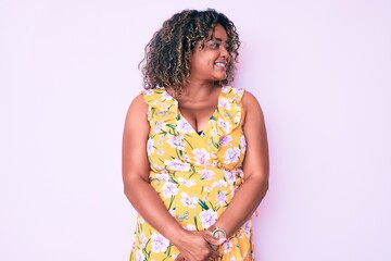 Young african american plus size woman wearing casual clothes looking away to side with smile on face, natural expression. laughing confident.