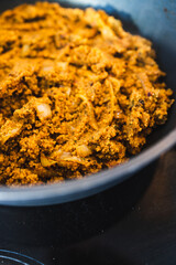 plant-based food, vegan spicy cous cous with moroccan spices and turmeric cooking in the pan