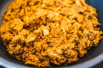 plant-based food, vegan spicy cous cous with moroccan spices and turmeric cooking in the pan