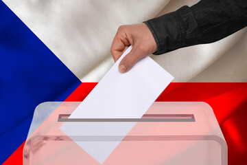 male voter drops a ballot in a transparent ballot box against the background of the Czech Republic national flag, concept of state elections, referendum