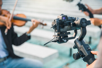 Video camera operator working with his equipment. Camera dslr is shooting . stabilizer control machine. movie technology.