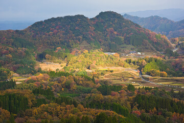 Fototapeta na wymiar 山の紅葉に差す朝日　高千穂峡の山々