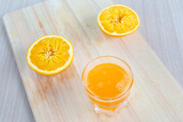 Fresh orange juice on wooden cutting board