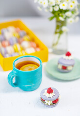 Delicious breakfast concept. Macaroon cake lies next to a cup of tea with lemon