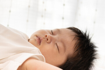 Obraz na płótnie Canvas 眠っている赤ちゃんの顔を横から撮った写真